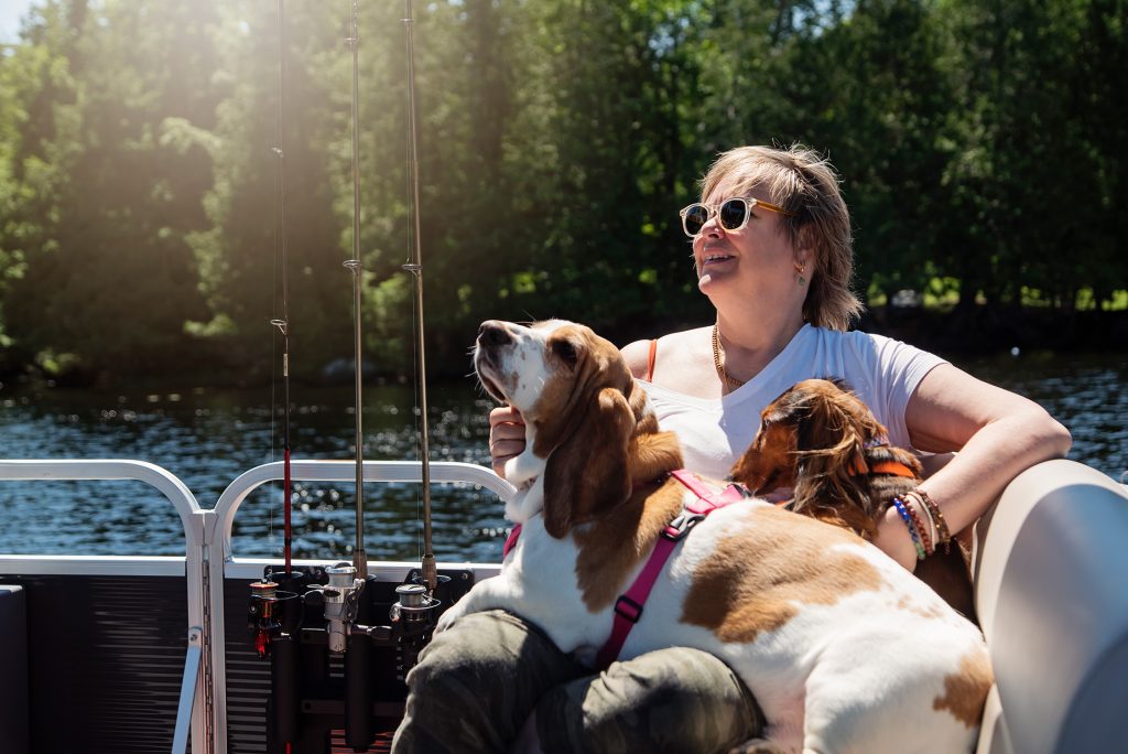 Femme sur un bateau avec 2 chiens